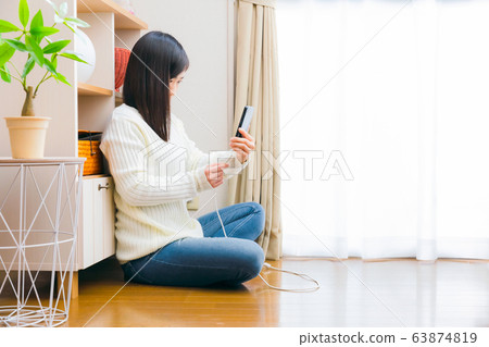 A woman who plugs in and pulls out the cable smartphone copy space 63874819