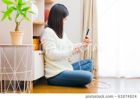 一個插入並拔出電纜智能手機複製空間的女人 一個插入並拔出電纜智能手機複製空間的女人 63874824