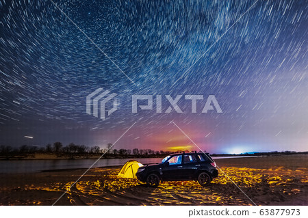 Night camping at the river. Star trails around the Night camping at the river. Star trails around the 63877973