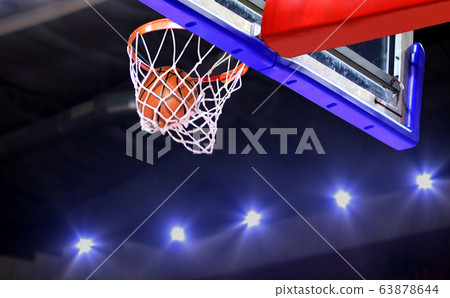Basketball shot to the hoop with bright spotlights Basketball shot to the hoop with bright spotlights 63878644