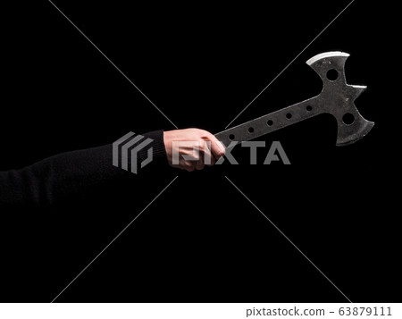 Woman's hand holding steel throwing axe on black background 63879111