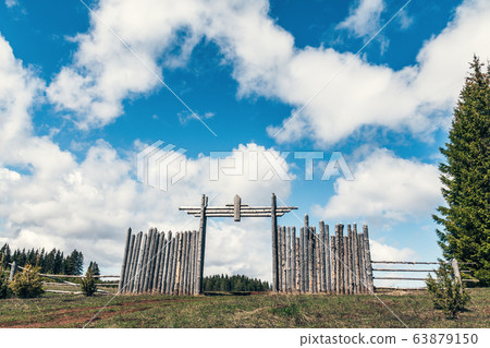 Wooden fence and gate against the blue sky with white clouds 63879150