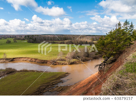 View from the high bank at the river bend and grassy plain. Shadows of clouds running across the plain View from the high bank at the river bend and grassy plain. Shadows of clouds running across the plain 63879157