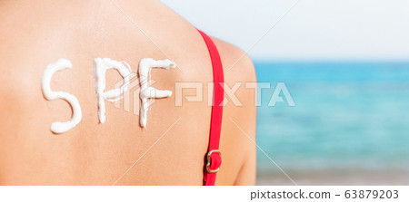 SPF word made of sunblock at woman's back at the 63879203