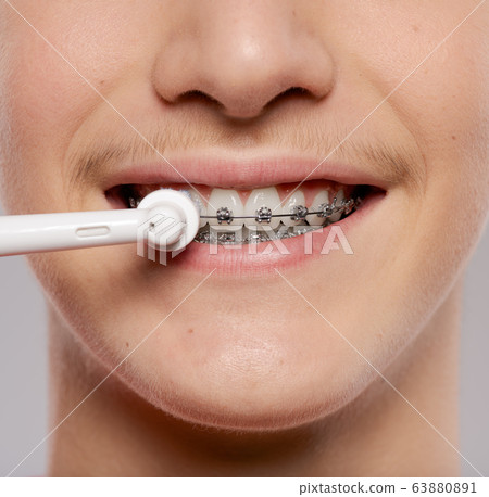Photo of  young man taking care of his teeth. 63880891