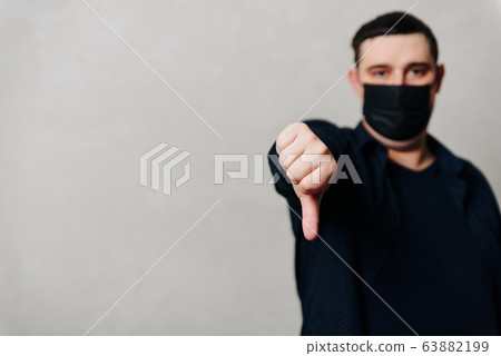 a man in a black medical mask on a gray background 63882199