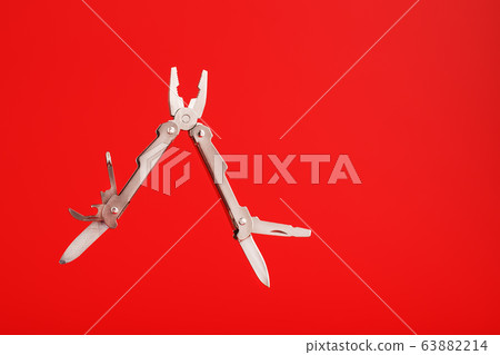 Multitool is a multi-functional tool on a red Multitool is a multi-functional tool on a red 63882214