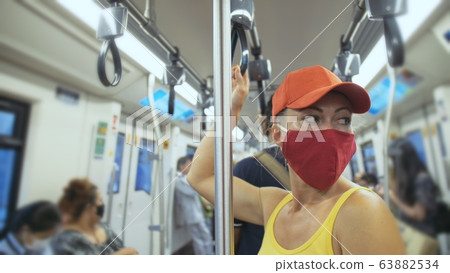 Woman travel caucasian ride at overground train airtrain with wearing protective medical mask. Girl tourist at airtrain with respirator. People mask. 63882534