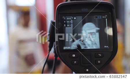 Temperature check at a supermarket, grocery store with a thermal imaging camera installed. Coronavirus pandemic outbreak. 63882547