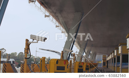 Antibacterial and antiviral treatment of toll roads in Thailand. Spraying chemical fluid over cars. Disinfection of vehicles roads. Pandemic covid-19. 63882560