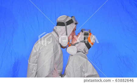 Doctor man and woman in protective costume suit, gas protect medical spray paint mask. Love couple kiss and hug, health worker in respirator Covid-19. Doctor man and woman in protective costume suit, gas protect medical spray paint mask. Love couple kiss and hug, health worker in respirator Covid-19. 63882646