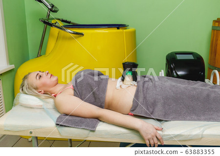 Woman getting cryolipolysis fat treatment Woman getting cryolipolysis fat treatment 63883355