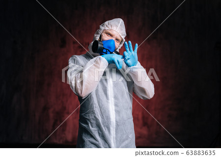 Virologist wearing hazmat, goggles and respirator showing nasty gesture. 63883635