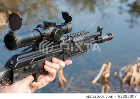 A man is holding a rifle aim and magazine A man is holding a rifle aim and magazine 63883807