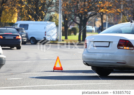 There is yellow triangle accident sign on road 63885702