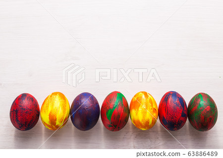Holidays, traditions and Easter concept - Multi-colored decorative colourful eggs on white background with copy space. Top view. 63886489