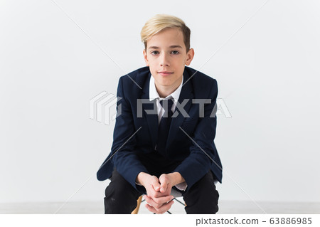 Portrait of stylish school boy teenager in white shirt and jacket against white background. Portrait of stylish school boy teenager in white shirt and jacket against white background. 63886985