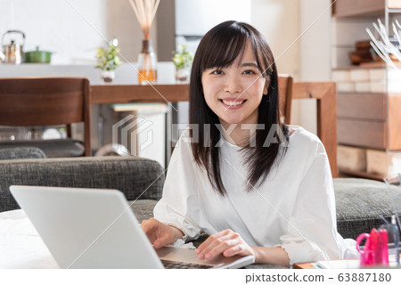 Young woman playing computer at home Young woman playing computer at home 63887180