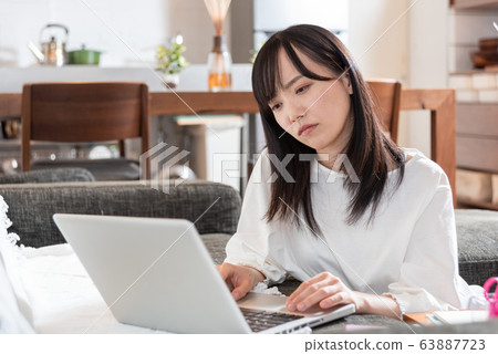Young woman thinking in living room Young woman thinking in living room 63887723