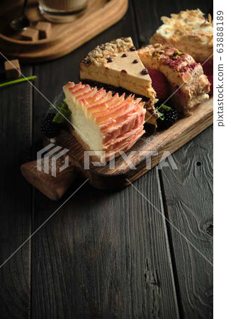Different pieces of cakes on a wooden board . catering menu 63888189
