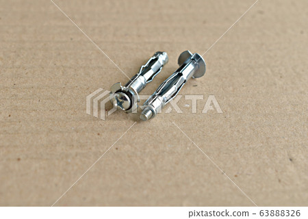 A pair of metal dowels on a gray table. A pair of metal dowels on a gray table. 63888326