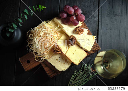 Glass of cold white wine with cheese snack on a wooden. catering menu 63888379