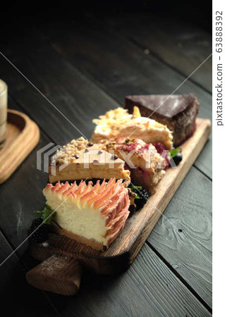 Different pieces of cakes on a wooden board . catering menu Different pieces of cakes on a wooden board . catering menu 63888392