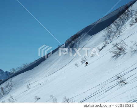 Mountain skier gliding with snow eaves in the background 63888528