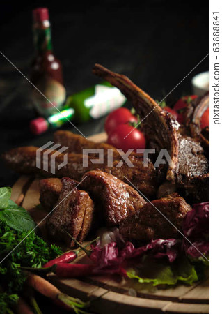 Meat on the bone on a wooden board . catering menu 63888841