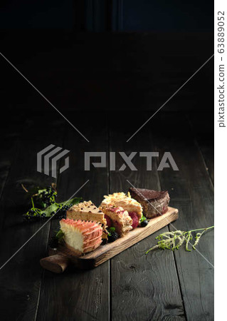 Different pieces of cakes on a wooden board . catering menu Different pieces of cakes on a wooden board . catering menu 63889052