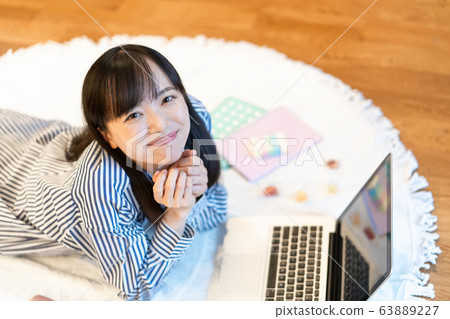 年輕女子躺在客廳裡吃糖果 63889227