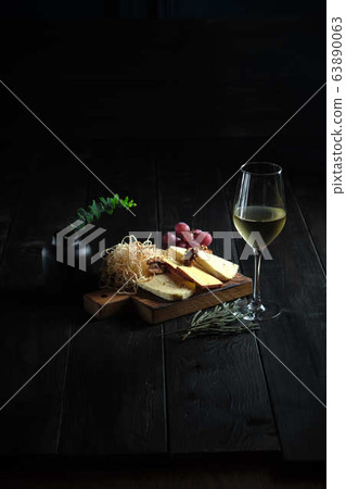 Glass of cold white wine with cheese snack on a wooden. catering menu 63890063