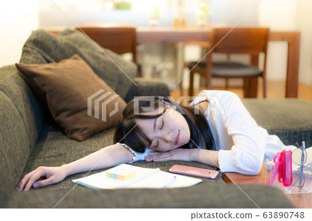 Young woman leaning on sofa in living room Young woman leaning on sofa in living room 63890748