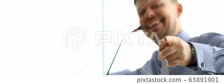 Smiling man points his finger towards microphone 63891901