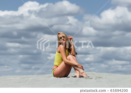 Seductive woman in stylish swimsuit kneeling in 63894200