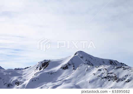 Sunlit snowy slopes in high winter mountains and Sunlit snowy slopes in high winter mountains and 63895082