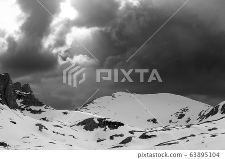 Snowy mountains and storm clouds 63895104