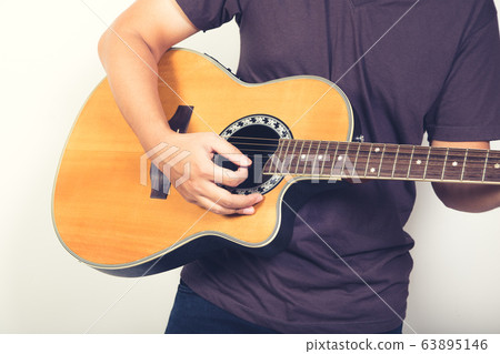 man playing guitar acoustic wearing t-shirt close up shot on white background 63895146