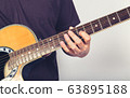 man playing guitar acoustic wearing t-shirt close up shot on white background 63895188