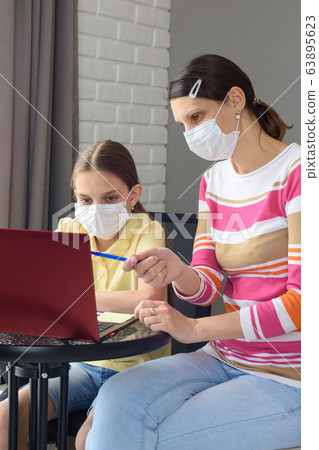 The girl helps the child to do quarantine lessons The girl helps the child to do quarantine lessons 63895623