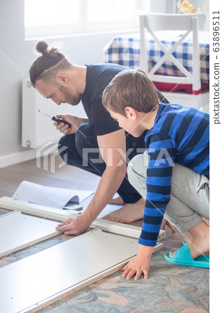 Father and son working together Father and son working together 63896511
