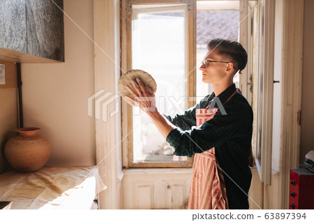 Male potter works with clay. Hand's of man creating ceramic product 63897394