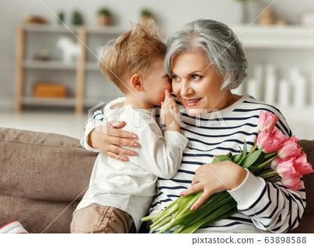Little boy congratulating grandmother with Little boy congratulating grandmother with 63898588