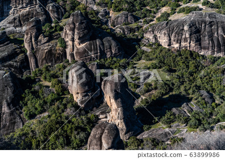 Aerial view of Unesco monument Meteora, the mountains, the landmark of Greek, sunny weather, fog, haze over a valley Aerial view of Unesco monument Meteora, the mountains, the landmark of Greek, sunny weather, fog, haze over a valley 63899986