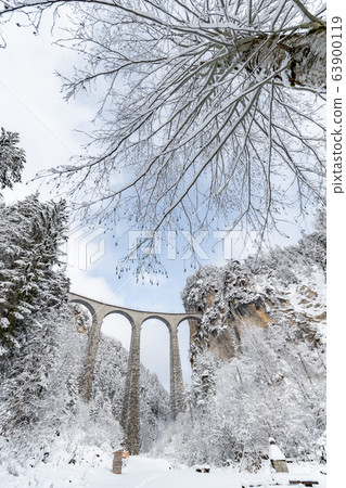 The Landwasser Viaduct with Railway without famous train at winter, landmark of Switzerland, snowing, river and mountains 63900119