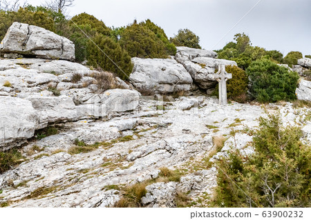 The sacred cross St.Pilon is on the mountain in cloudy weather, clouds over a valley, a dry grass, mountain over grotto of Mary Magdalene The sacred cross St.Pilon is on the mountain in cloudy weather, clouds over a valley, a dry grass, mountain over grotto of Mary Magdalene 63900232