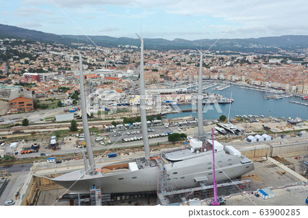 Aerial view of sea dry dock in La Ciotat city, France, the cargo crane, boats on repair, a luxury sail yacht and motor yacht, mountain is on background, shipyard Aerial view of sea dry dock in La Ciotat city, France, the cargo crane, boats on repair, a luxury sail yacht and motor yacht, mountain is on background, shipyard 63900285