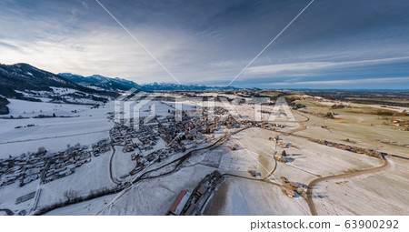 Aerial view of the small cozy german town at the mountain bottom at sunrise in a winter season, Halblech city, Germany, Bavaria, Branches of trees are covered with hoarfrost, sunny weather Aerial view of the small cozy german town at the mountain bottom at sunrise in a winter season, Halblech city, Germany, Bavaria, Branches of trees are covered with hoarfrost, sunny weather 63900292