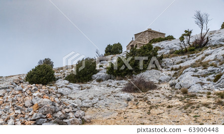 The chapel Saint-Pilon is on the mountain in cloudy weather, clouds over a valley, a dry grass, mountain over grotto of Mary Magdalene 63900448