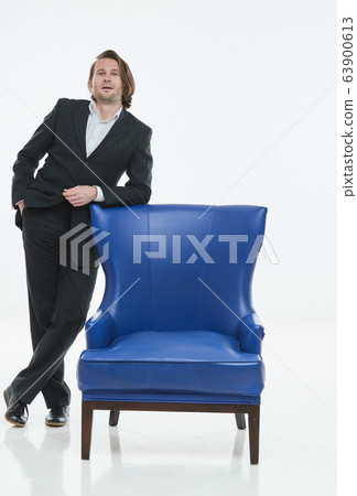 The handsome men in black suit is at blue leather chair, white background, brutal man with long hairs, white shirts, business man, very stylish 63900613